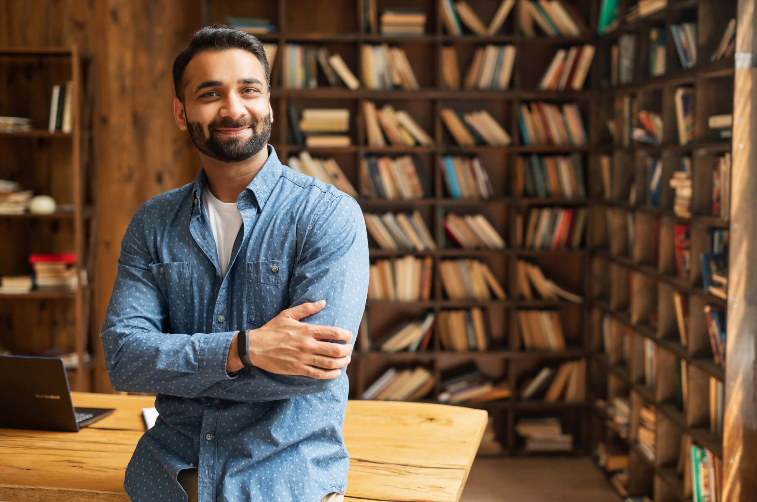 Smiling,Bearded,Indian,Businessman,Stands,Near,Desk,And,Looks,At True North Financial Services Brandon McElroy