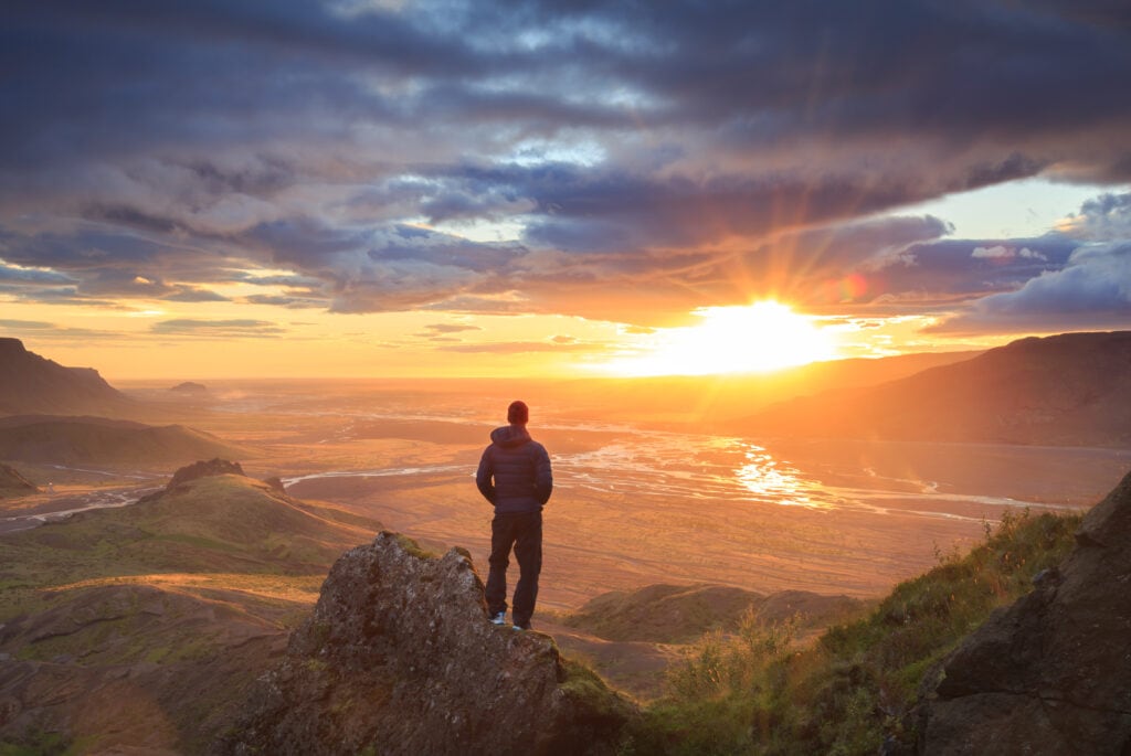 Man,Standing,On,A,Ledge,Of,A,Mountain,,Enjoying,The True North Financial Services Brandon McElroy